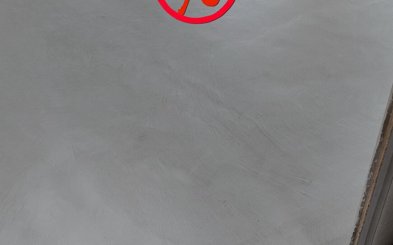 Raw and cloudy microcement wall in raking light